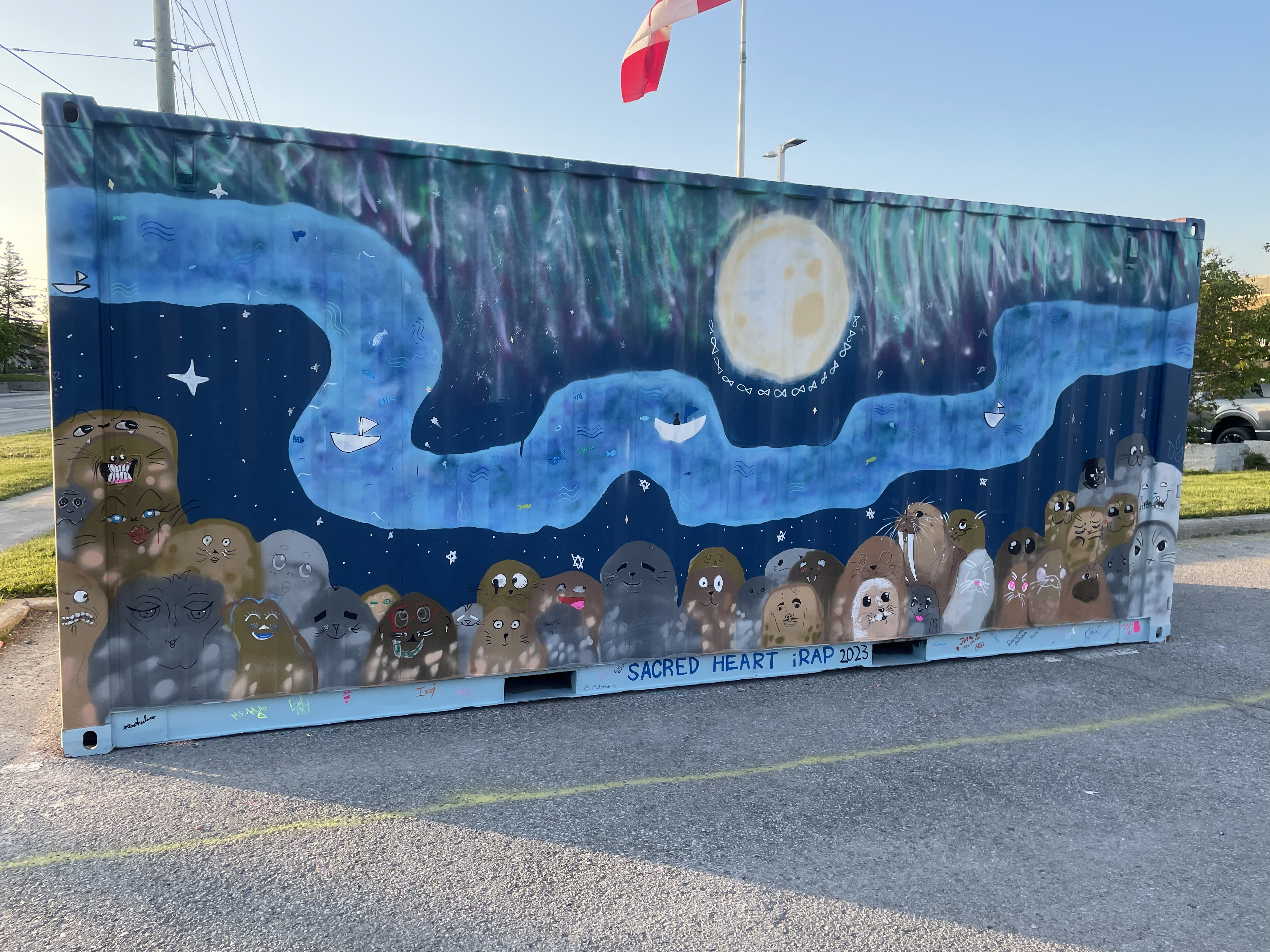 Local Catholic high school students painted a mural on the container filled with 16,000 pounds of food for Sanirajak.